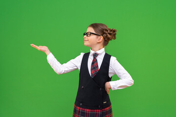 A joyful schoolgirl holds your advertisement on her hand. A little girl in a school uniform points to an advertisement.