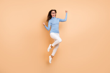 Fototapeta na wymiar Full body photo of impressed millennial lady jump yell wear eyewear pullover pants shoes isolated on beige background