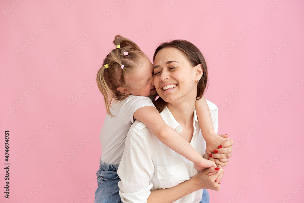 Wall mural the daughter gives a kiss to her mother on the cheek. mother's day concept, mother and daughter love