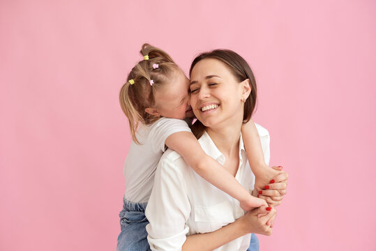 The daughter gives a kiss to her mother on the cheek. Mother's day concept, mother and daughter love