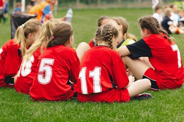 Group of girls in youth female soccer team. Female sports soccer team outdoors. Female physical education class on a sports grass field. Young football players of a female youth sports team