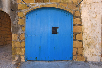 old wooden blue double garage door in a wall