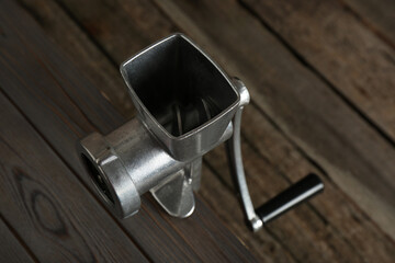 Metal manual meat grinder on wooden table, above view