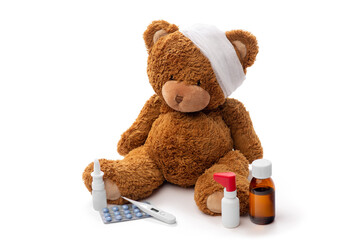 medicine, healthcare and childhood concept - teddy bear toy with bandaged head thermometer and...