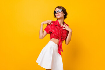 Photo of young beautiful pretty charming girl in sunglasses dancing look copyspace isolated on yellow color background