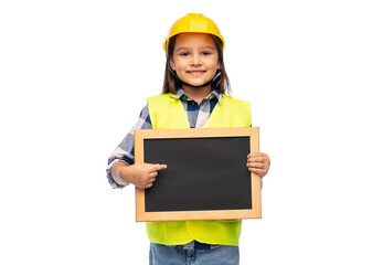 building, construction and profession concept - smiling little girl in protective helmet and safety vest holding chalkboard over white background