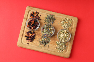 Concept of cooking tea with different types of tea on red background
