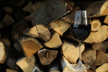 Glass of wine outdoor on folded firewood