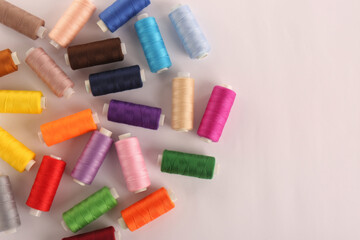 Set of colorful sewing threads on white background, top view