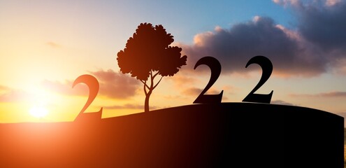 2022 text with tree on green grass field over sunset sky, Happy new year