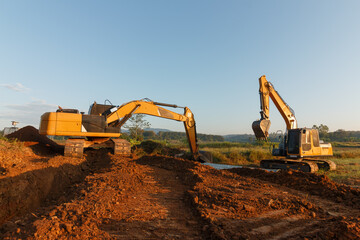 Two Crawler Excavator is digging in the construction site pipeline work on sky  background.in field
