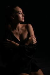 beautiful woman in black silk underwear in the dark