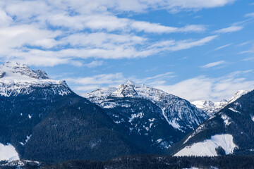 Fototapeta na wymiar panorama of high mountains covered by snow cloudy blue sky british columbia canada