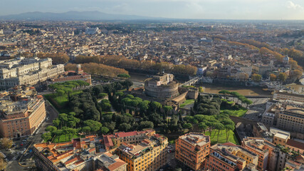 Aerial drone view of iconic Castel Sant'Angelo (castle of Holy Angel) and Ponte or bridge Sant'Angelo with statues in river of Tiber next to famous Vatican, Rome, Italy