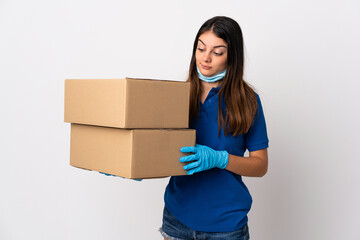 Young delivery woman protecting from the coronavirus with a mask isolated on white background with sad expression