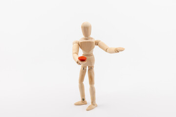 Wooden mannequin with pills on white background. Concept of pharmaceuticals and supplements.
