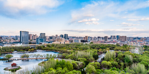 Fototapeta premium Ferris wheel and city skyline scenery in Qingcheng Park, Hohhot, Inner Mongolia, China