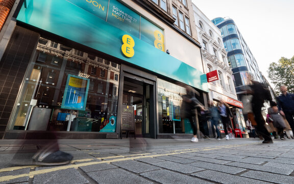 The EE Store, Oxford Street, London. Shoppers passing the UK high street mobile phone and telecoms store on London's busy shopping district.