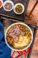 Beef noodles with sauerkraut in old altar on wooden table 