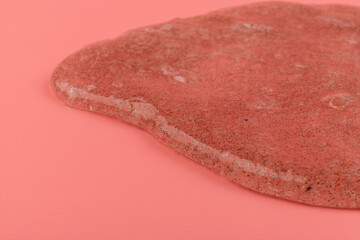 Coral transparent slime with bubbles inside on pink background. Kids toy slime.
