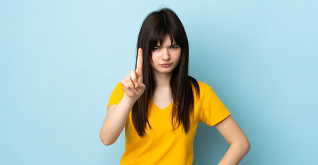 Fototapeta premium Teenager Ukrainian girl isolated on blue background counting one with serious expression