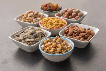 Yellow chickpea in selective focus. Dried mulberry, hazelnut, pistachio, grape, pistachio, almond and sunflower seeds in the background.