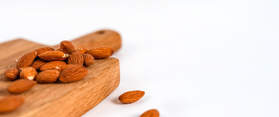 Almonds nuts on a wooden board on a white background