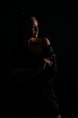 beautiful woman in black silk underwear in the dark