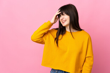 Young Ukrainian woman isolated on pink background smiling a lot