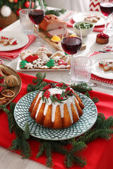 Festive dinner with delicious cake served on table indoors. Christmas Eve celebration