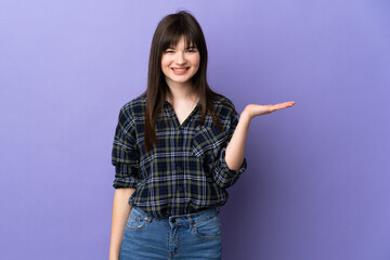 Young Ukrainian woman isolated on purple background holding copyspace imaginary on the palm to...