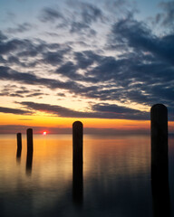 Sunset on the bay with wood pilings along the seashore of  the Outer Banks of North Carolina