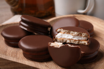 Tasty choco pies on wooden plate, closeup view