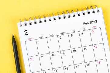 February 2022 desk calendar on yellow.