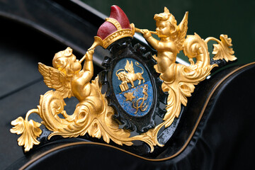 Gilt detail of gondola in Venice: badge with two winged putti with trumpets