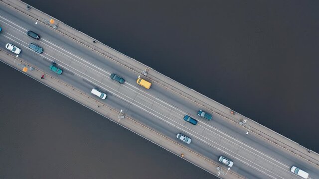 Urban car traffic on the bridge over the river. Shooting with a drone.