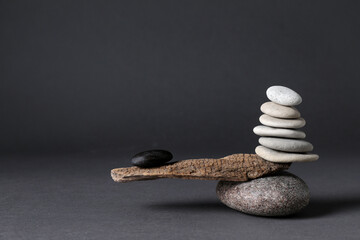 Stones with tree branch on black background. Harmony and balance concept