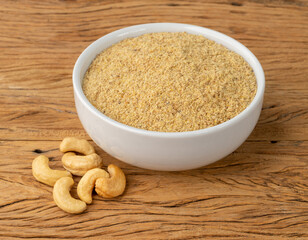 Cashew nut flour in a bowl over wooden table. Gluten free flour