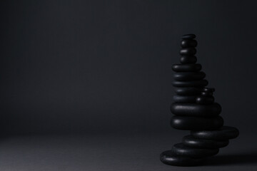 Stack of stones on black background, space for text. Harmony and balance concept