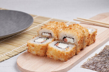 a portion of rolls on a stand, japanese food, sushi on the table, chinese chopsticks, light background
