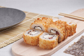 a portion of rolls on a stand, japanese food, sushi on the table, chinese chopsticks, light background