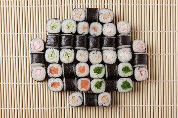 a portion of different rolls on the table, japanese food, sushi set on marble, top view, chinese chopsticks