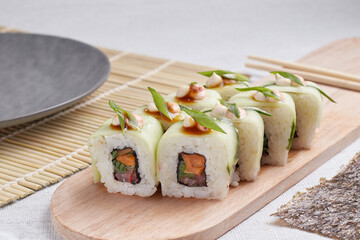 a portion of rolls on a stand, japanese food, sushi on the table, chinese chopsticks, light background