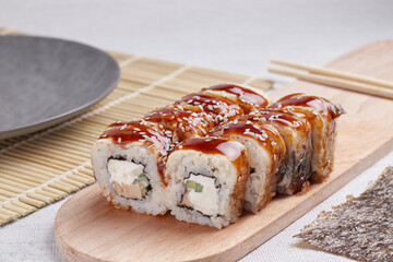 a portion of rolls on a stand, japanese food, sushi on the table, chinese chopsticks, light background