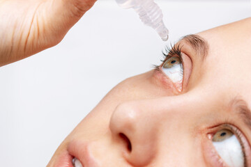 Close-up of woman dripping her eye with medicinal drops natural tear. Disease of retina of eye....