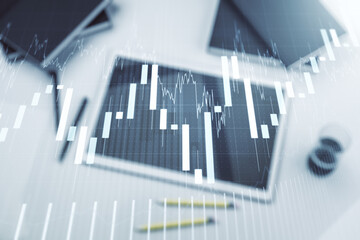 Abstract creative financial graph and modern digital tablet on desktop on background, top view, financial and trading concept. Multiexposure