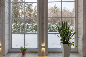 Winter landscape seen through the big window in wooden house scandinavian style