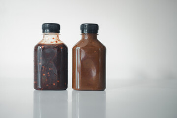 Two styles of Thai spicy sauce in a plastic bottle.
