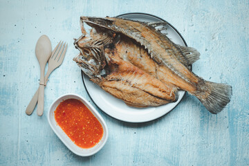 Crispy Thai style deep fried whole sea bass fish served with spicy sauce