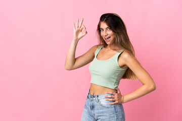 Young caucasian woman isolated on pink background showing ok sign with fingers